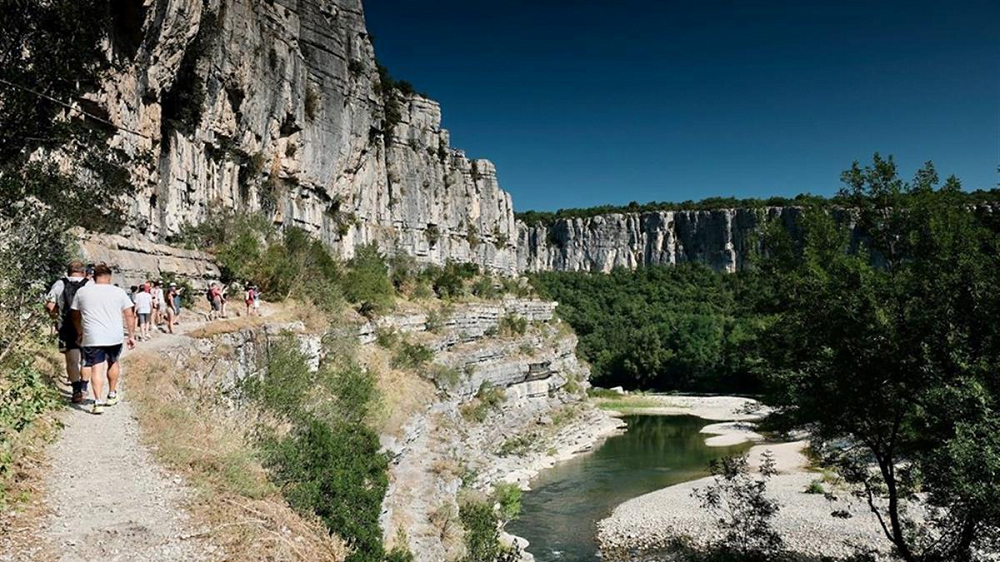 Randonnée au Cirque de Gens, entre falaises et rivière Randonneurs sur le sentier balisé du Cirque de Gens, longeant les falaises.