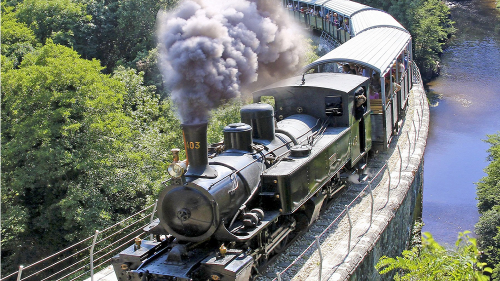 Train de l’Ardèche dans les Gorges du Doux Le Train de l’Ardèche à vapeur traversant les Gorges du Doux sous un panache de fumée
