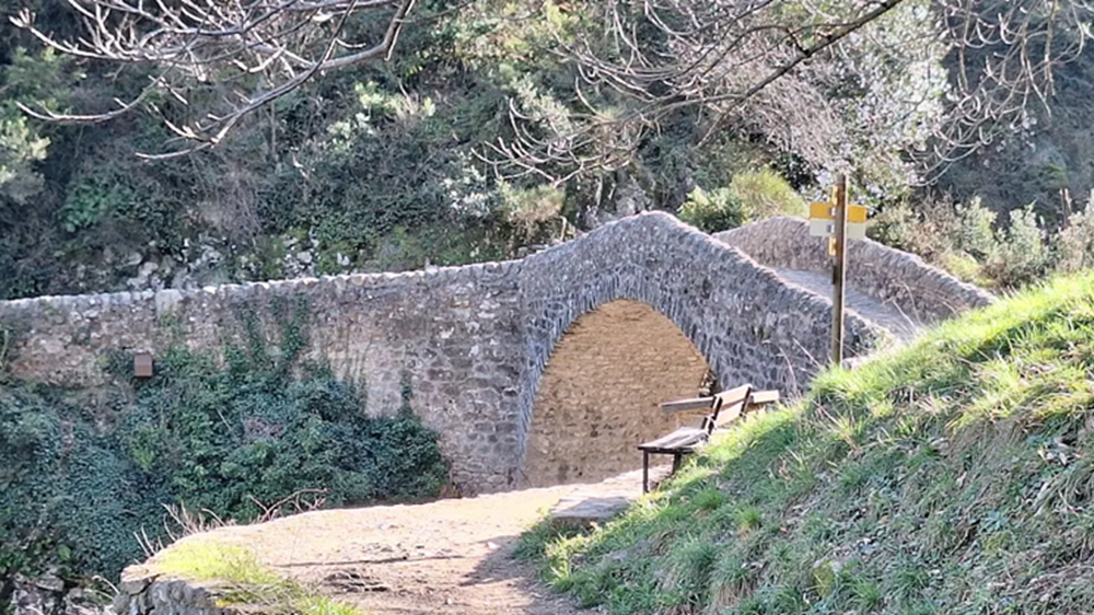 Un site naturel impressionnant autour du Pont du Diable en Ardèche Vue du Pont du Diable à Thueyts avec des randonneurs sur le sentier et la rivière Ardèche en contrebas, dans un paysage de gorges verdoyantes