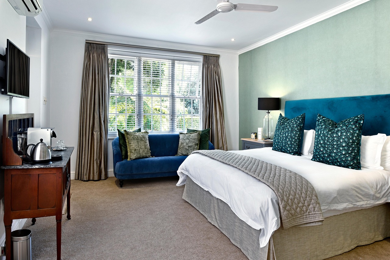 Quelle différence entre hôtel et chambre d'hôtes 45 Chambre double lumineuse avec lit, canapé et décoration élégante, utilisée pour montrer la différence entre hôtel et chambre d’hôtes.