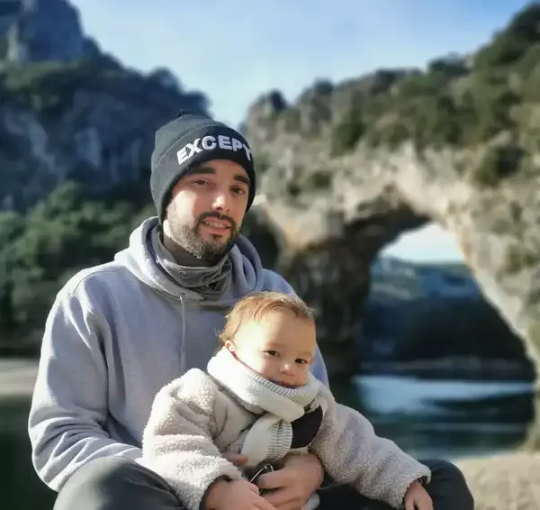 Pierre, hôte de la Villa Font Vive, devant le Pont d'Arc en Ardèche, partageant sa passion de la randonnée et du tourisme durable.