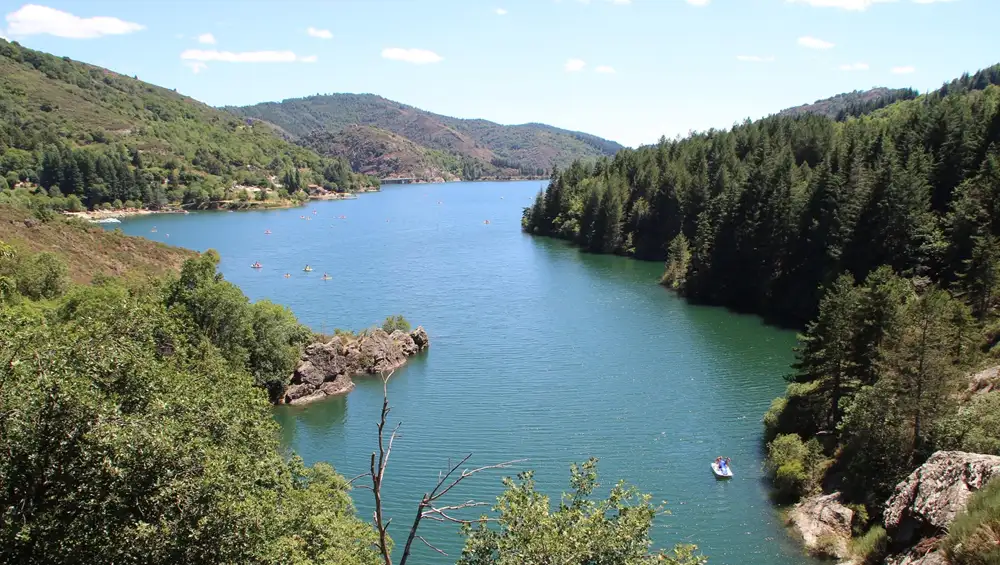 vue-panoramique-randonnee-lac-villefort Vue panoramique élevée sur le lac de Villefort entouré de collines boisées des Cévennes, prise depuis le sentier de randonnée le tour du lac.